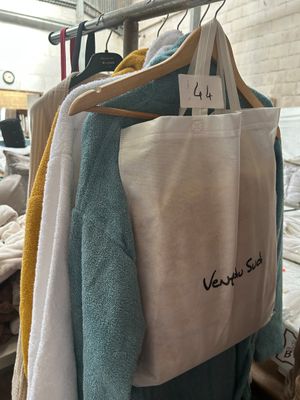 a white bag hanging on a clothes rack in a room