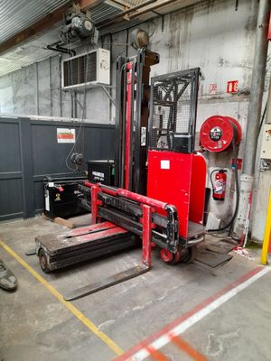 a red forklift in a warehouse with other equipment