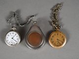 trois types différents de montres de poche posées sur la table