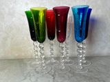 quatre verres à vin de couleurs différentes posés sur une table