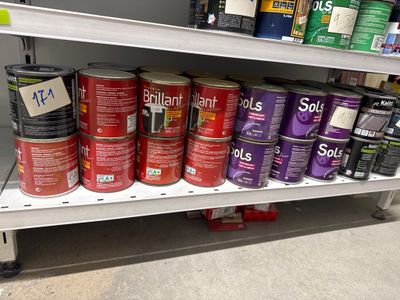 de nombreux pots de peinture sur une étagère dans un magasin