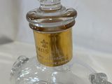 a clear glass bottle with a gold top on a table