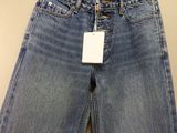 a pair of jeans hanging on a hanger on a wall