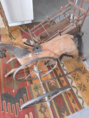 un cheval tirant une charrette sur un tapis dans le salon