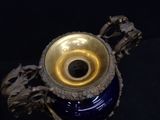 a blue and gold vase on a black surface
