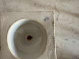 underside view of a white porcelain toilet bowl with a hole in the middle