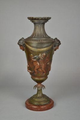a bronze vase on a wooden stand with a white background