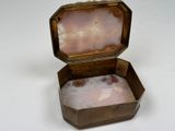 a small wooden box with a pink stone inside of it