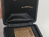 an image of a gold cigarette case sitting in a black box