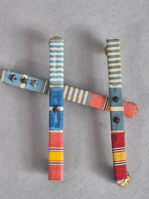 Trois bâtonnets en bois, de couleurs et de motifs différents, sont disposés sur une table.