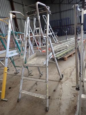 many ladders that are sitting in a warehouse