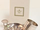 a silver plate with a cup on it next to a box