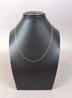 a black mannequin with a gold chain on it