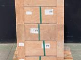 une pile de cartons posée sur une palette devant un mur noir