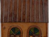 a small wooden house with two windows and a door