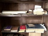 Des livres sont empilés sur une étagère en bois dans une pièce