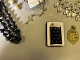 a lot of jewelry on a table with a cell phone