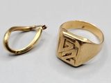 une image représentant une bague en or et une boucle d'oreille en or posées sur une surface blanche