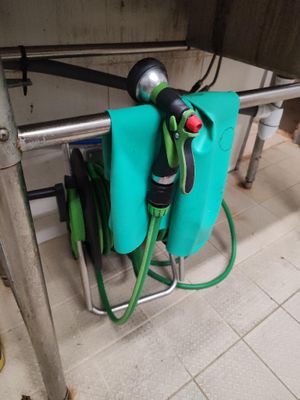 un tuyau vert relié à un sac bleu posé par terre