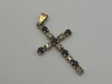 une croix en or ornée de pierres bleues et blanches sur un fond blanc