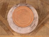 an image of a clay pot on a wooden floor