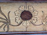 a close up of a piece of wood with a flower on it