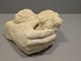 une sculpture représentant une main tenant un bébé dans ses bras
