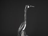 a clear glass sculpture of a bird on a black background