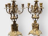 pair of antique brass candelabs with candles on stands