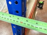 a measuring tape on the side of a shelf in a warehouse