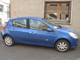 a small blue car parked in front of a building