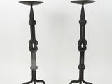 a pair of black iron candlesticks with a circular design