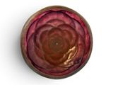 a bowl with a flower inside of it on a white surface