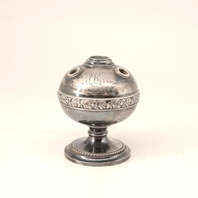 un vase en argent posé sur un socle, sur fond blanc