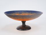 un bol bleu et orange posé sur un socle noir