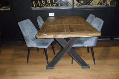une table en bois entourée de quatre chaises dans une pièce