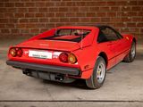 a red sports car parked in front of a brick wall