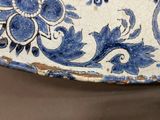 a close up of a blue and white plate with flowers on it