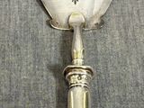 une cuillère en argent décorée, posée sur une table