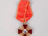 une image représentant une médaille rouge et dorée ornée d'une croix