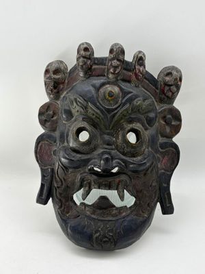 an image of a black mask with a face made out of wood