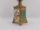 a small gold and blue vase with flowers on it