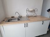 a woman standing in a kitchen with a sink and a dishwasher
