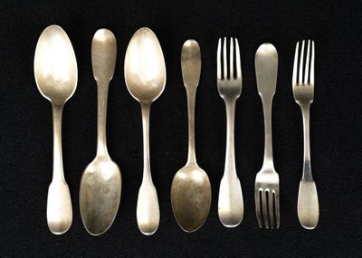 five spoons and a fork on a black table