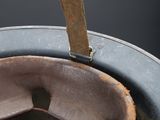 a metal bucket with a wooden handle hanging from it