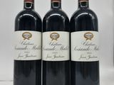 trois bouteilles de vin rouge posées sur un plan de travail blanc