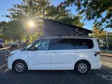 the white van is parked on the side of the road with its roof open