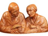 une statue représentant deux personnes assises l'une à côté de l'autre