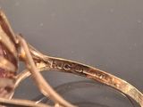 a close up of a ring with a pink stone on it