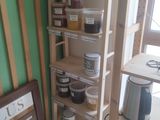 a shelf with jars and jars on it in the corner of a room